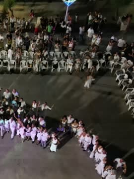 Un cerchio di ballerini in bianco visto dall'alto