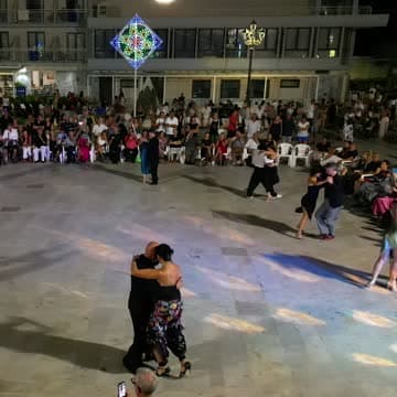 Coppie di tango sulla pista illuminata